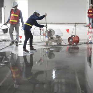stock-photo-construction-worker-painting-epoxy-flooring-floor-hardener